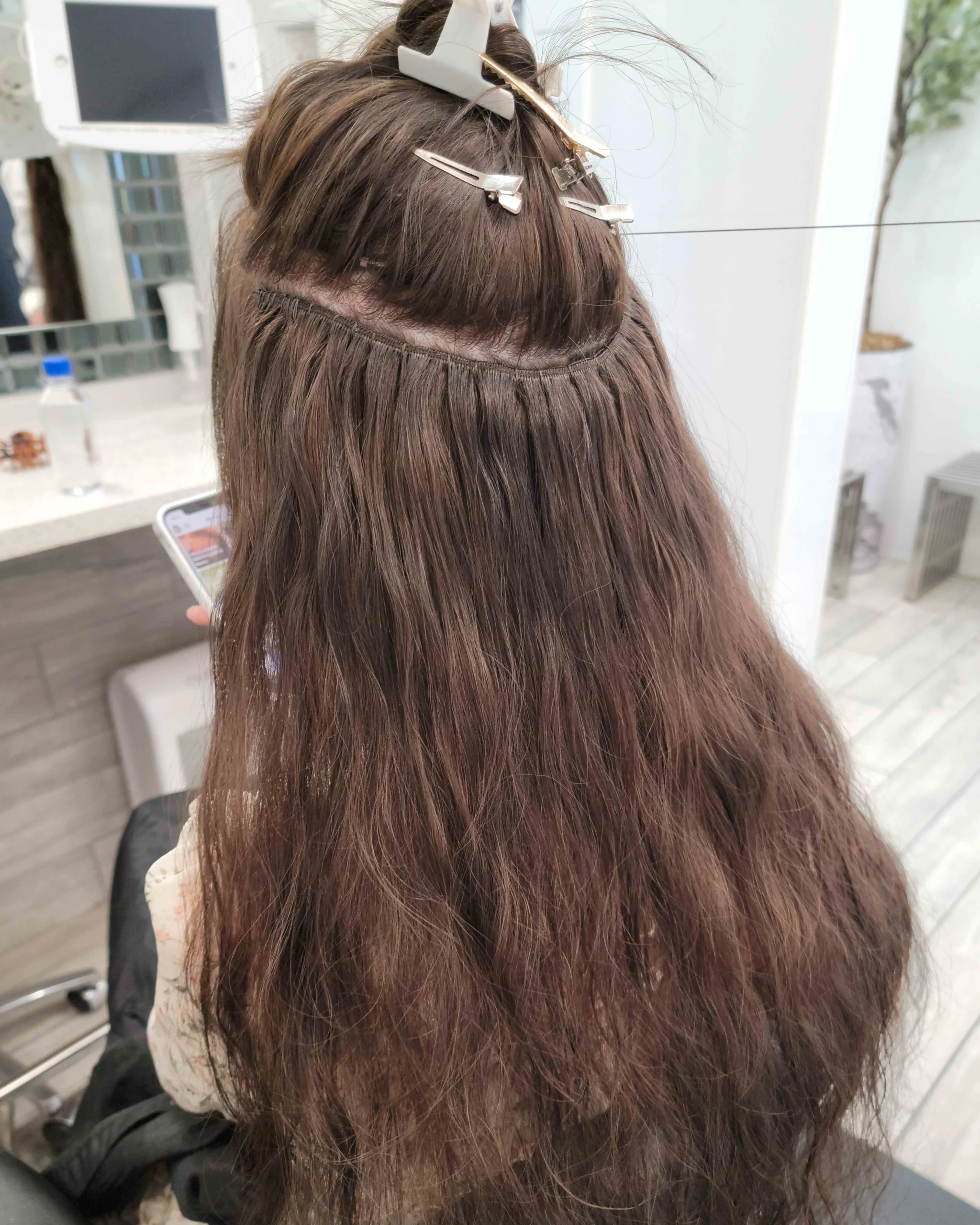 Before and after weft hair extensions showing transformation from short hair to long wavy length with natural blends